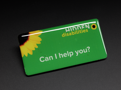 "Can I help you" staff badge for business partners with a sunflower and the Hidden Disabilities logo